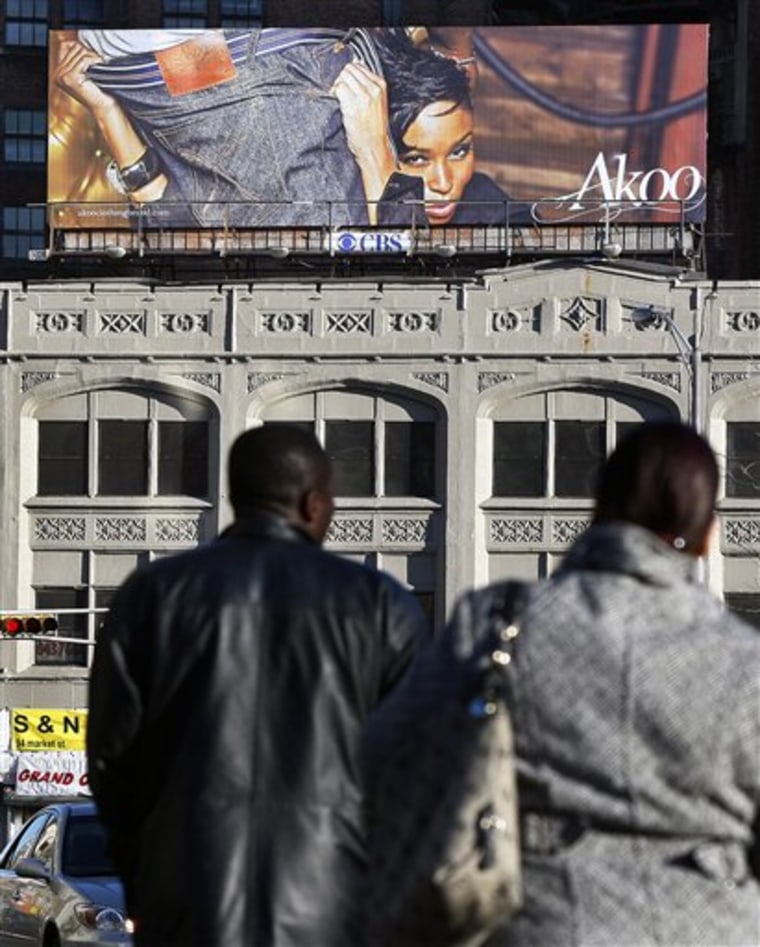 A suggestive advertising billboard for Akoo jeans hangs above Market Street in downtown Newark, N.J.